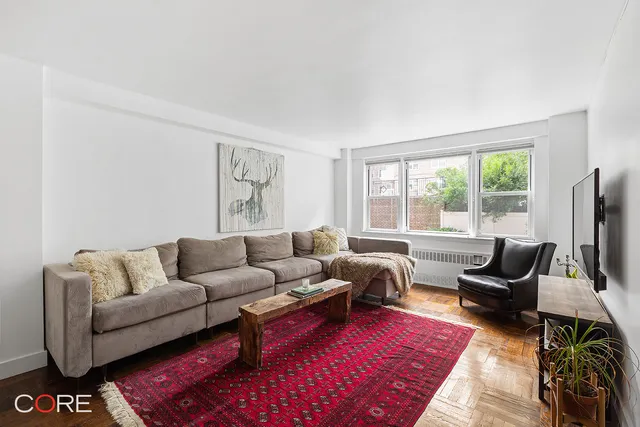 a living room with furniture a rug and a flat screen tv