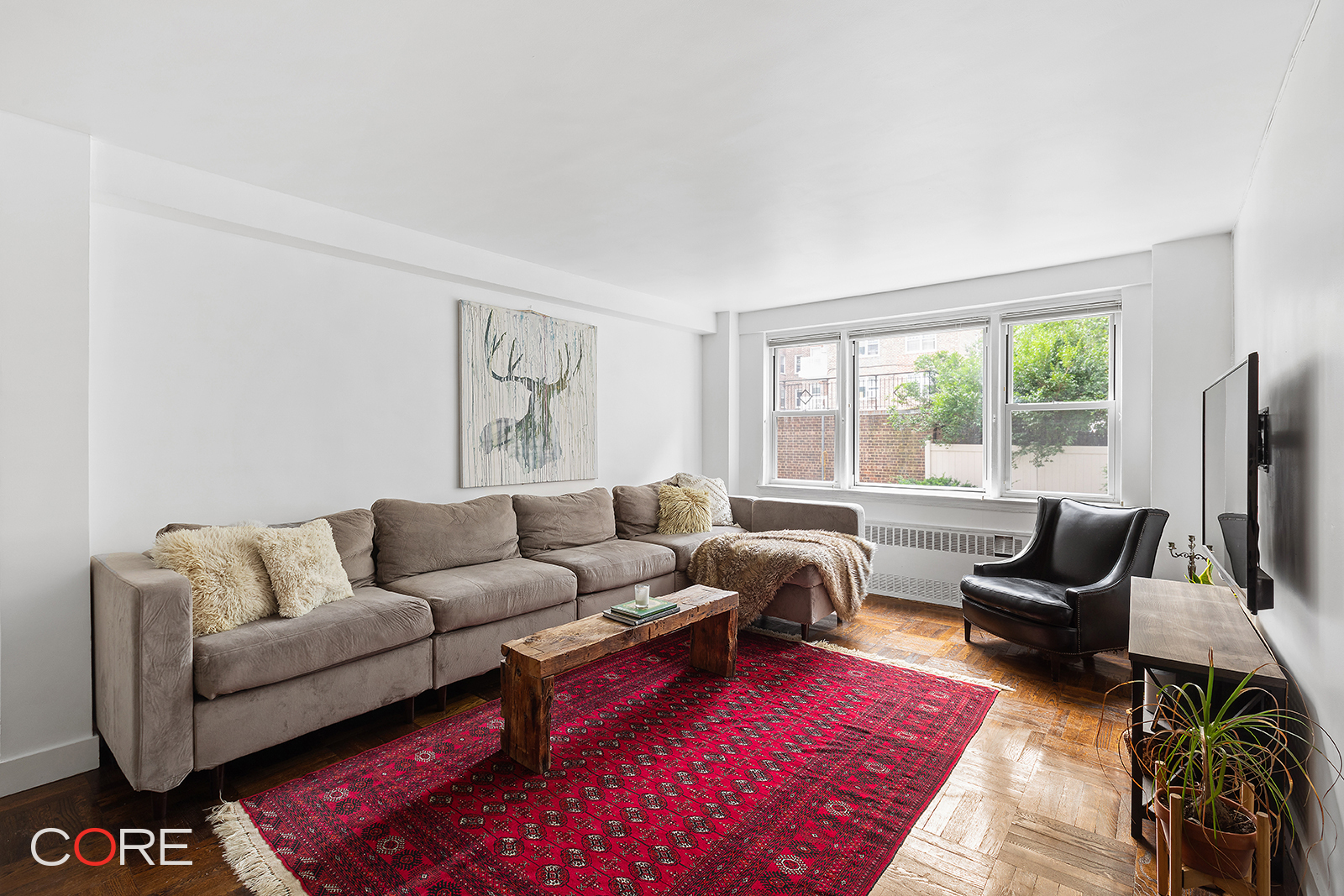 a living room with furniture a rug and a flat screen tv
