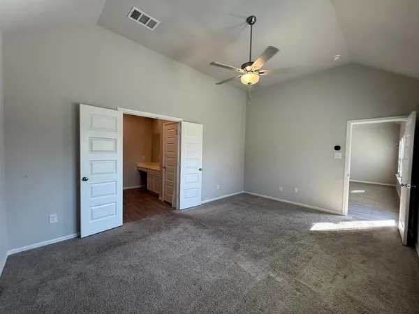 an empty room with a windows and ceiling fan