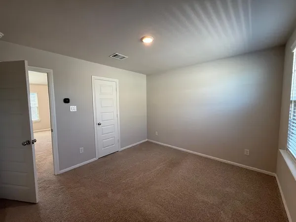 an empty room with closet and windows