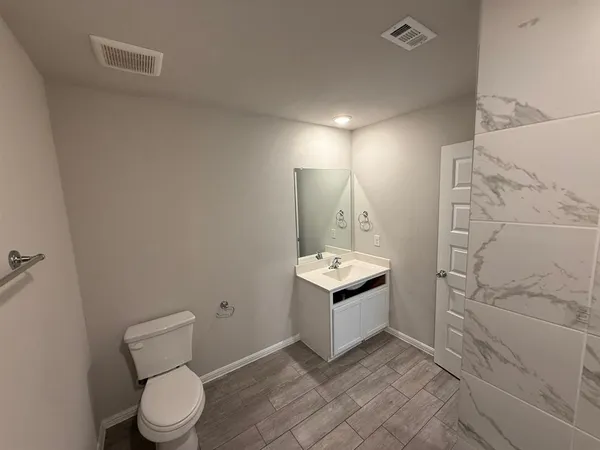 a bathroom with a granite countertop toilet a sink and bathtub