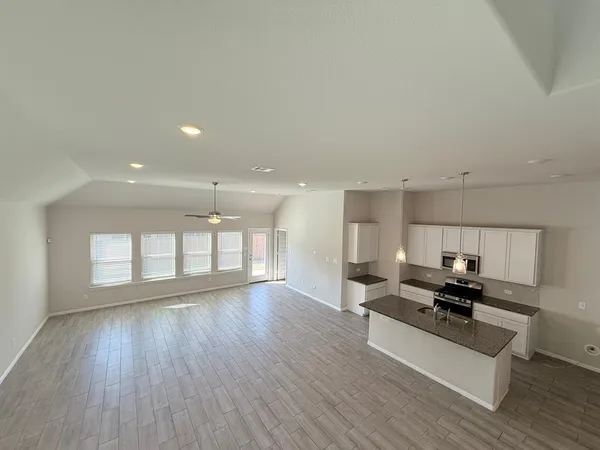 a kitchen with stainless steel appliances granite countertop a sink a stove and a wooden floors