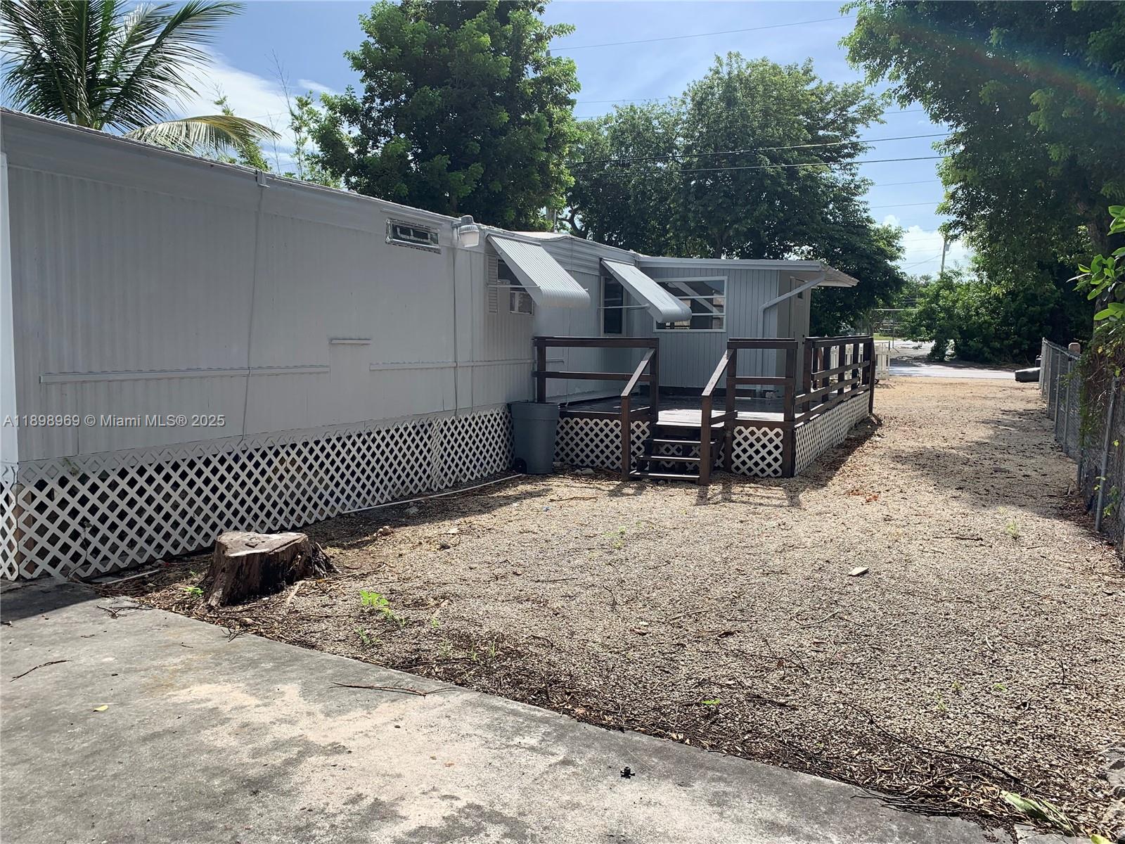 740 Largo Road, Unit 740 Key Largo, FL 33037 - Photo 6 of 7 a backyard of a house with table and chairs