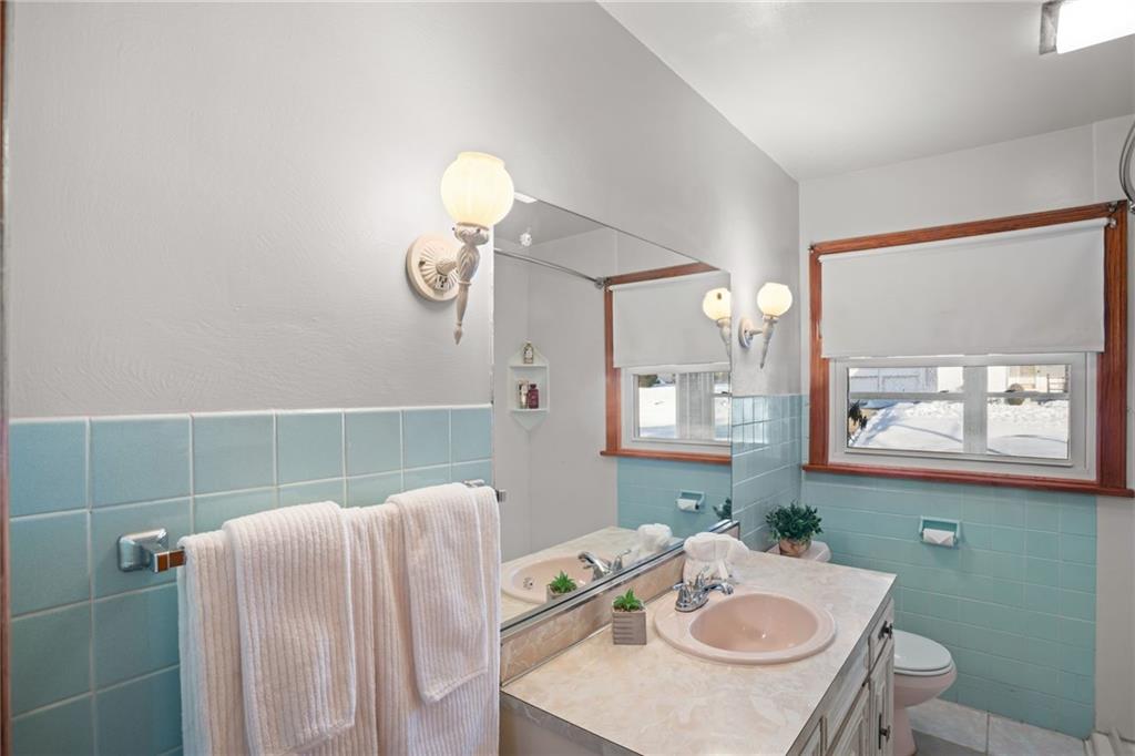 738 Addis Street New Castle, PA 16101 - Photo 22 of 50 a bathroom with a granite countertop sink a toilet and a mirror