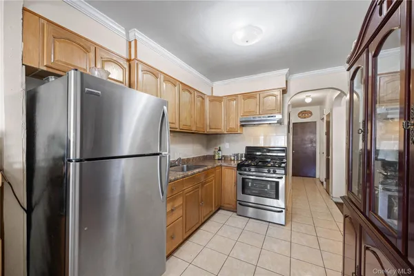 a kitchen with stainless steel appliances granite countertop a refrigerator and a stove top oven