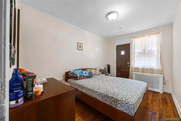 a bedroom with a bed and a dresser next to a window