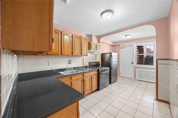a kitchen with stainless steel appliances granite countertop a refrigerator a stove top oven and sink