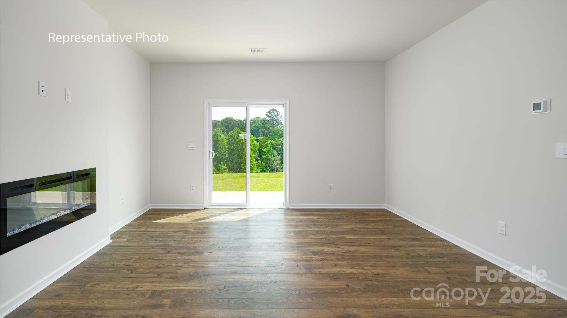 2668 Goose Fair Road Maiden, NC 28650 - Photo 9 of 28 a view of an empty room with wooden floor and a fireplace