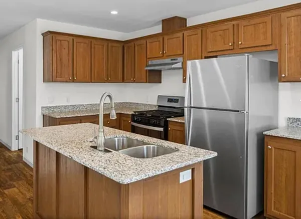 a kitchen with stainless steel appliances granite countertop a sink stove and refrigerator