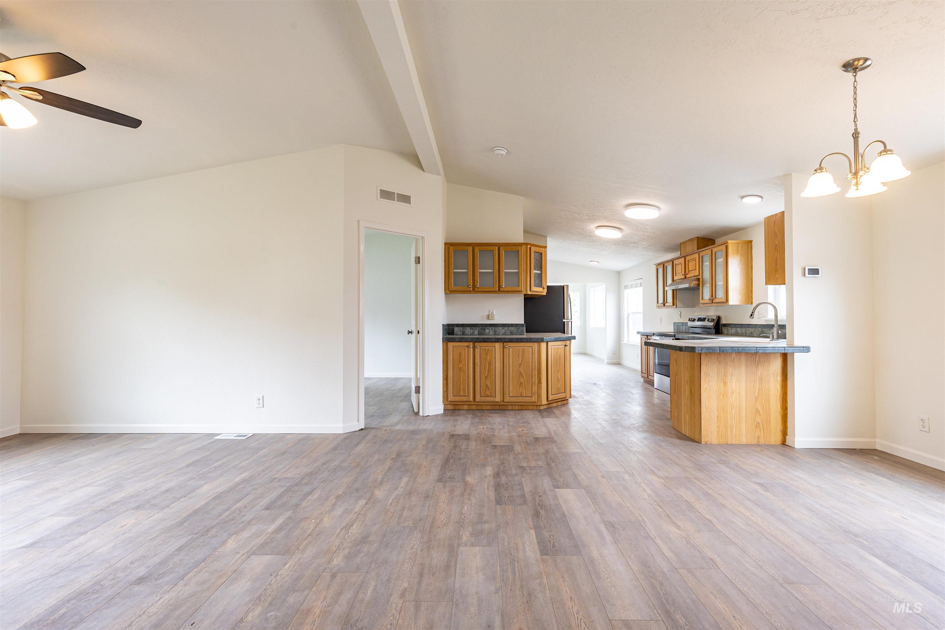 17028 Lower Pleasant Ridge Road Caldwell, ID 83607 - Photo 14 of 21 Spacious living area featuring wood-finish flooring, vaulted ceilings, and a ceiling fan