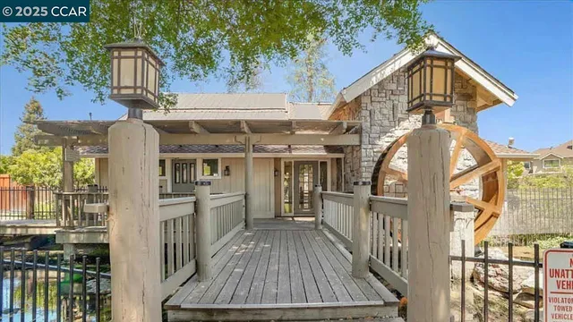 a view of a swimming pool with lawn chairs plants and large trees