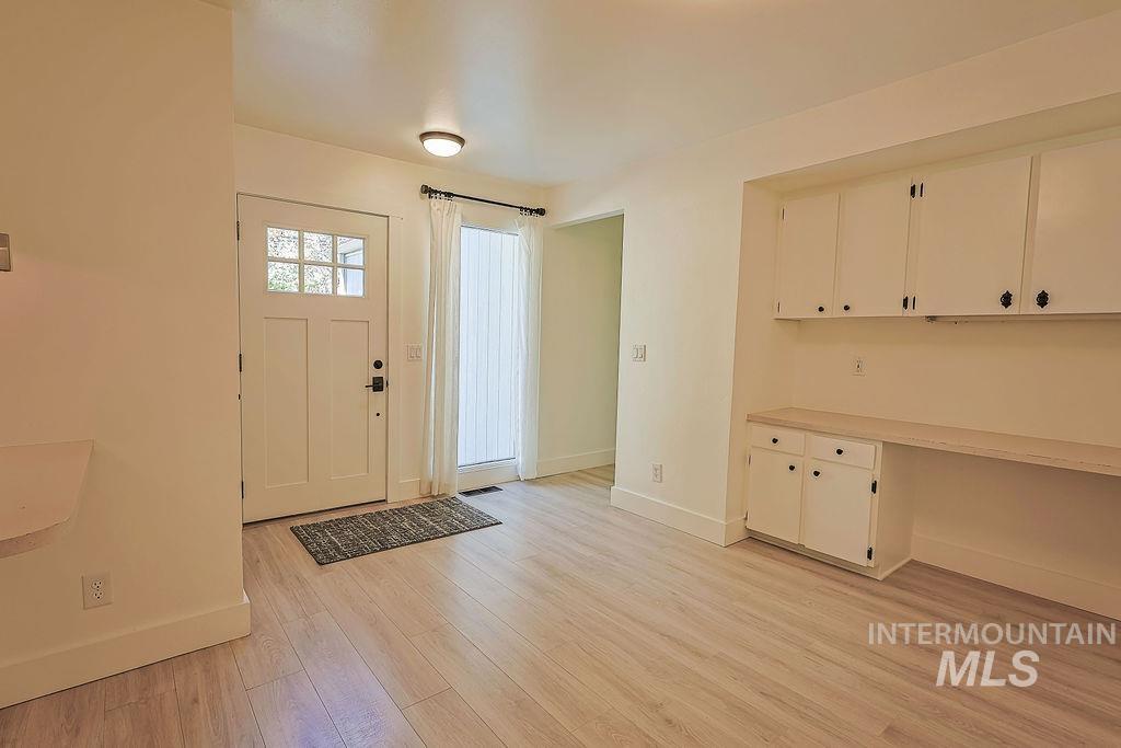 640 Morrison Street Twin Falls, ID 83301 - Photo 4 of 30 Entryway featuring a paneled door with glass inserts, wood-finish flooring, and a built-in desk with overhead cabinetry and lower storage