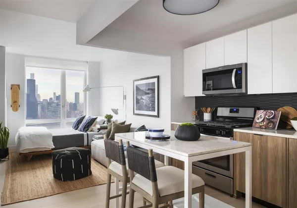 a kitchen with granite countertop a table chairs microwave and cabinets