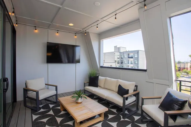 a bedroom with a bed and a flat tv screen on dresser