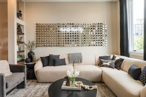 a work room with furniture a flat screen tv and a large window