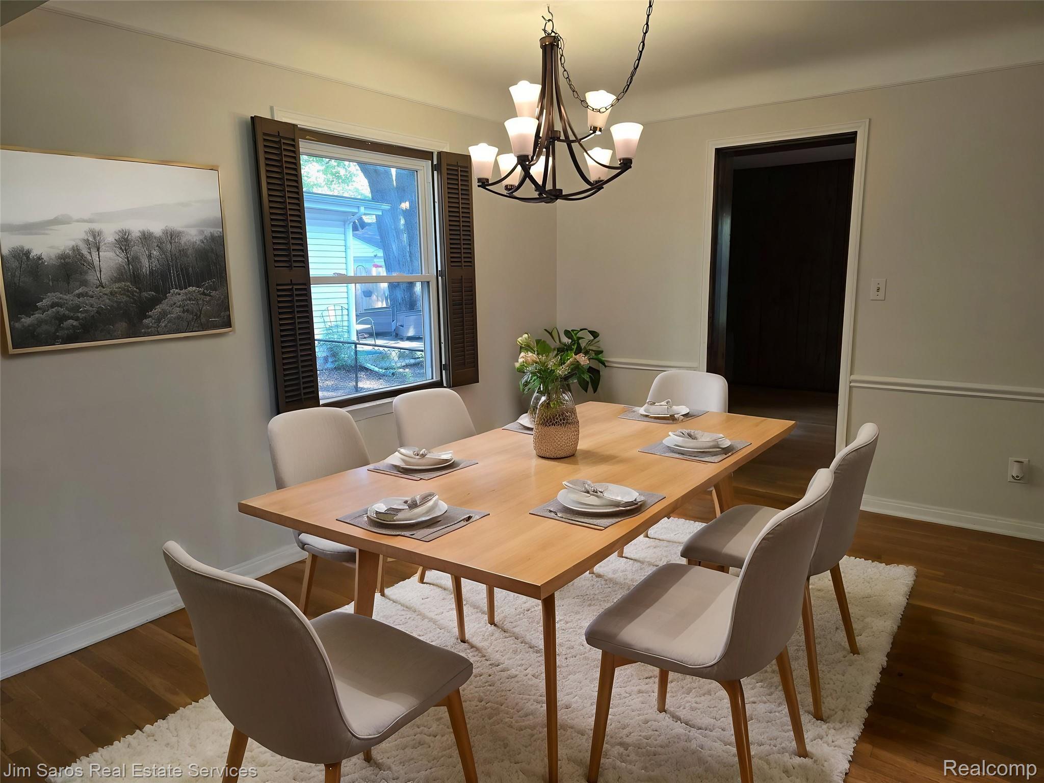 1762 Bournemouth Road Grosse Pointe, MI 48236 - Photo 6 of 21 Bright dining area featuring hardwood flooring, a multi-light chandelier, and a window with dark wood-finish shutters