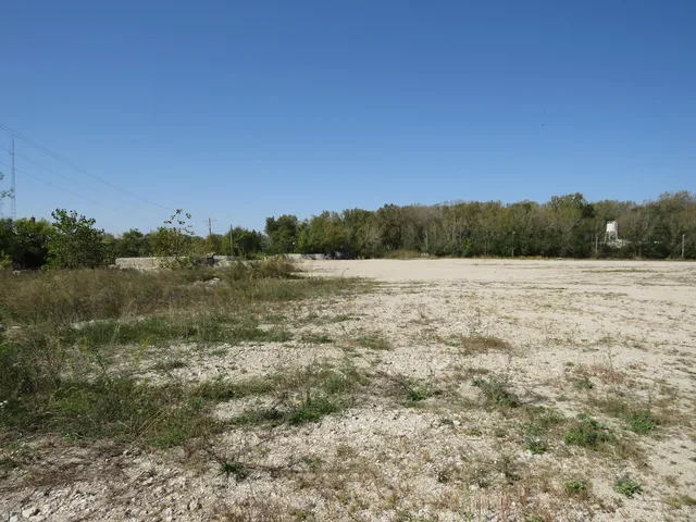 a view of a field with trees in the background