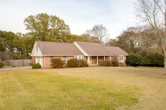 a front view of house with yard and trees around
