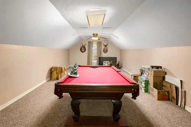 an empty room with windows and chandelier fan