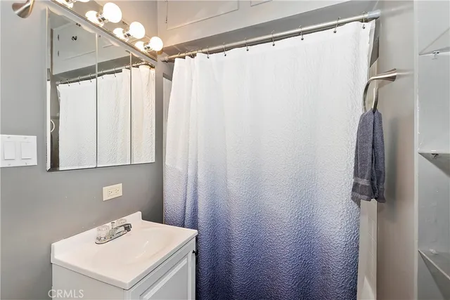 a bathroom with a sink a mirror and a shower curtain