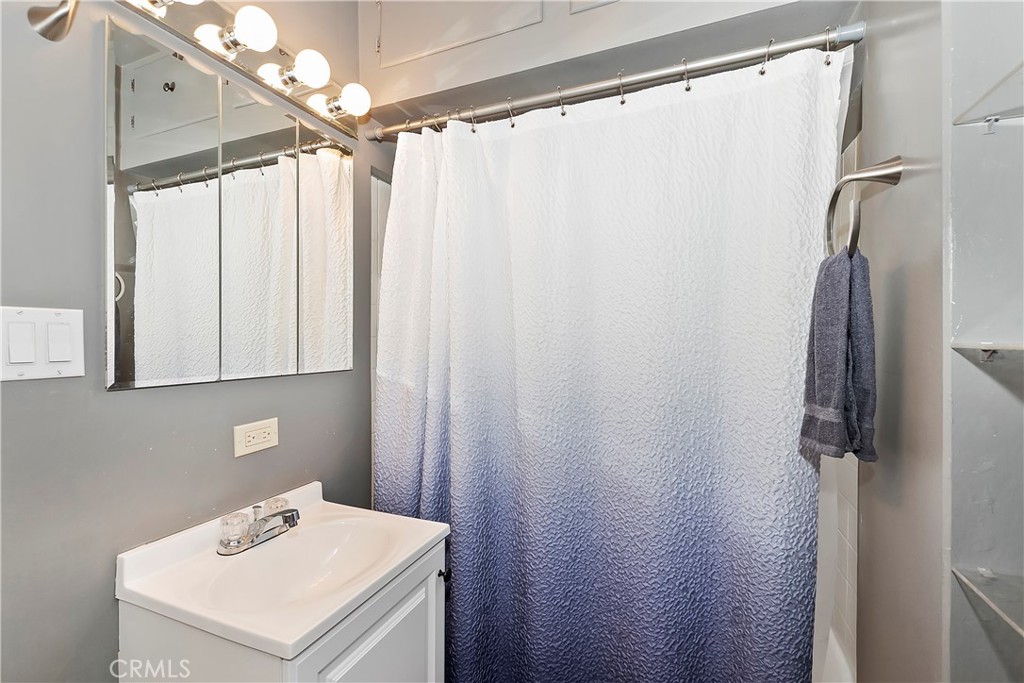 1262 Bear Springs Road Rimforest, CA 92378 - Photo 21 of 34 a bathroom with a sink a mirror and a shower curtain