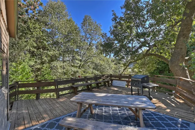 a view of a deck with table and chairs with wooden floor and fence
