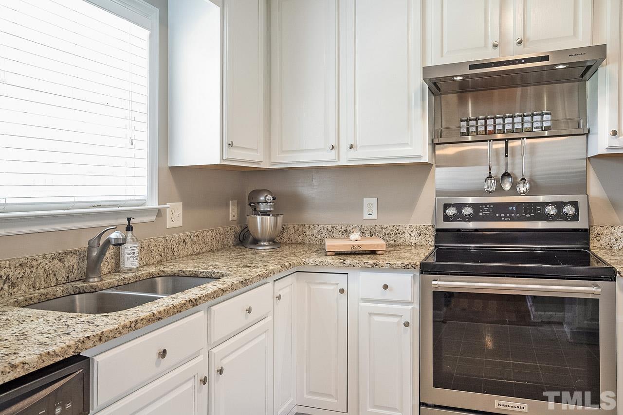 1140 Feldmen Drive Raleigh, NC 27603 - Photo 8 of 27 a kitchen with granite countertop white cabinets and white appliances