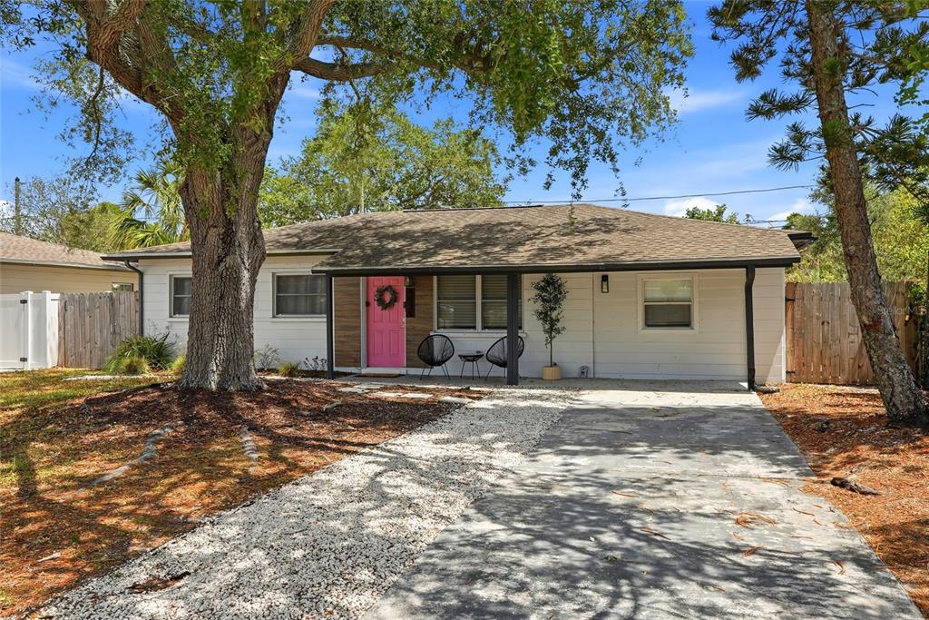 4939 100th Way North St. Petersburg, FL 33708 - Photo 2 of 43 a front view of a house with a garden and trees