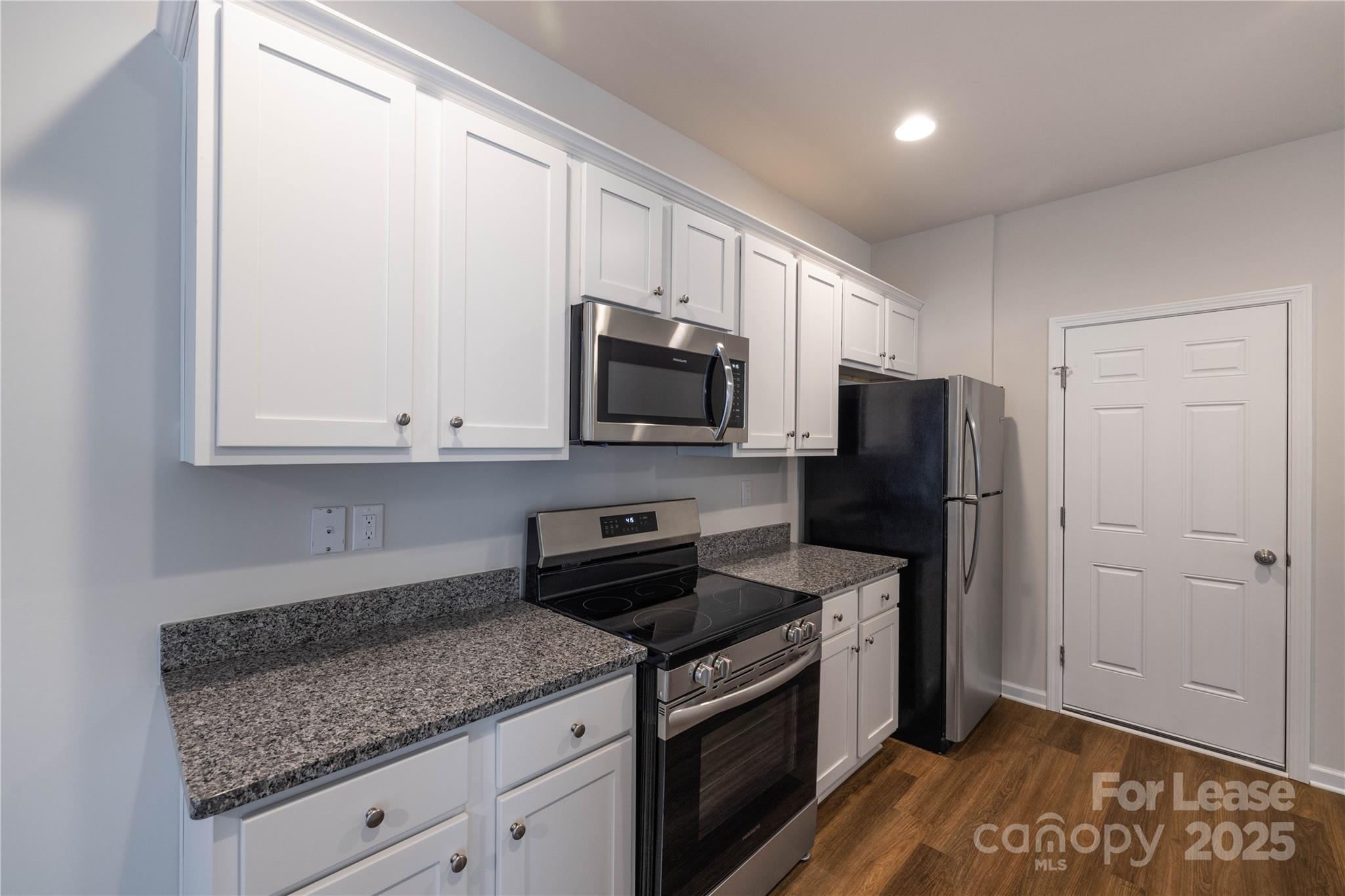 146 South Bell Avenue Albemarle, NC 28001 - Photo 11 of 36 a kitchen with granite countertop a refrigerator stove and microwave