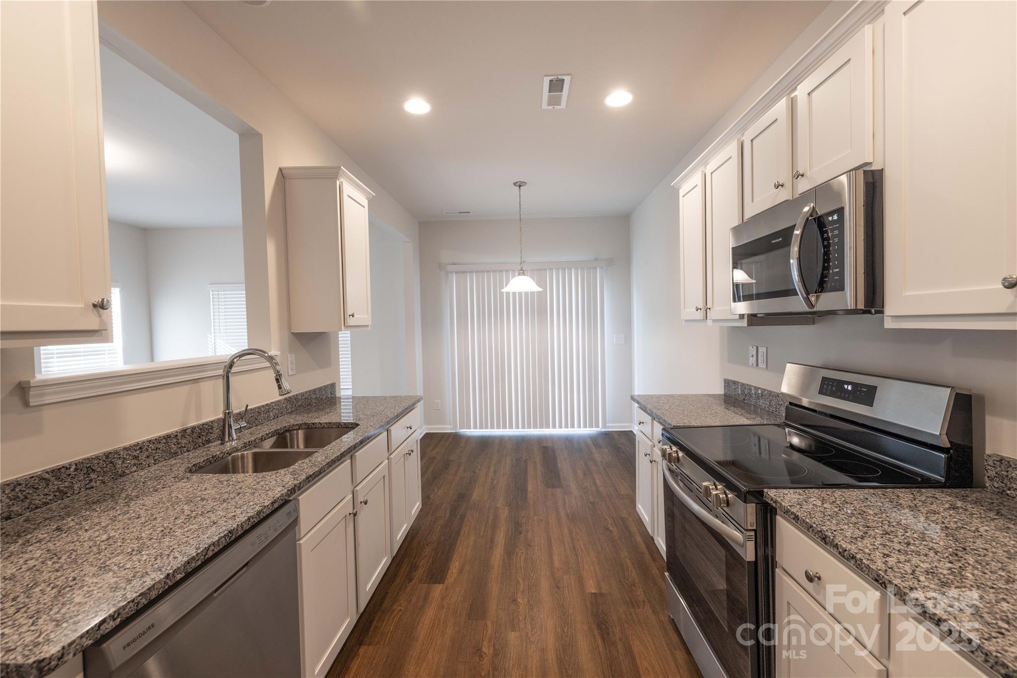 146 South Bell Avenue Albemarle, NC 28001 - Photo 15 of 36 a kitchen with granite countertop stainless steel appliances a stove sink microwave and cabinets