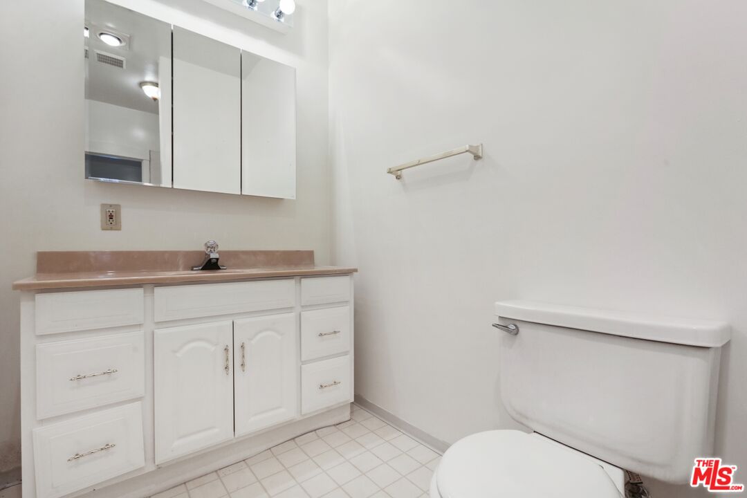 1126 Mohawk Street Los Angeles, CA 90026 - Photo 13 of 47 a bathroom with a granite countertop toilet sink and mirror