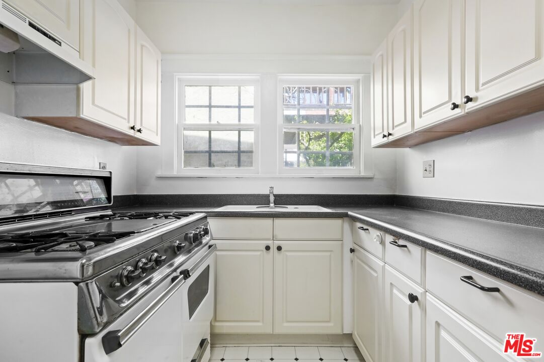 1126 Mohawk Street Los Angeles, CA 90026 - Photo 22 of 47 a kitchen with stainless steel appliances a sink a stove and white cabinets