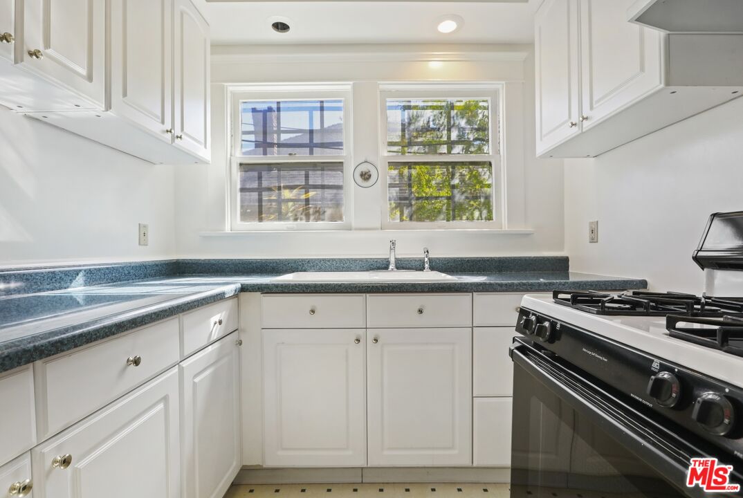 1126 Mohawk Street Los Angeles, CA 90026 - Photo 8 of 47 a kitchen with granite countertop white cabinets and a stove