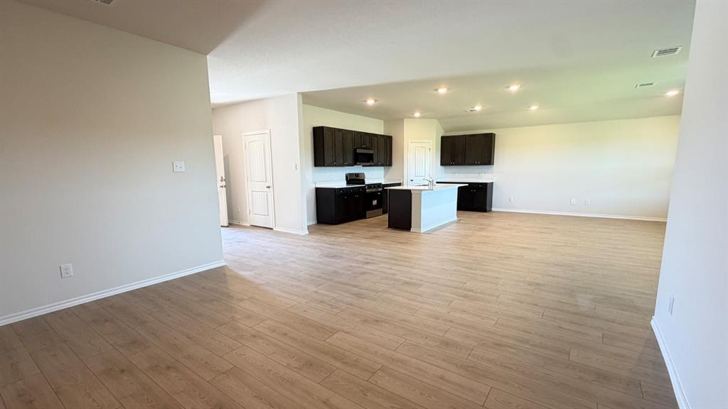 2007 Reveille Way Terrell, TX 75160 - Photo 19 of 31 an empty room with kitchen view and a flat screen tv