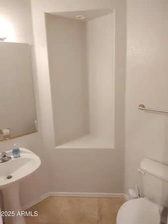 a white toilet sitting next to a bathroom sink
