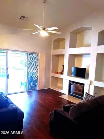 a living room with furniture a flat screen tv and a floor to ceiling window