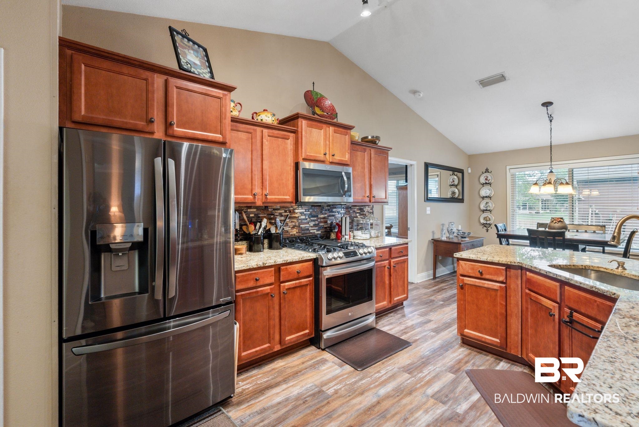 562 Vestige Mews Foley, AL 36535 - Photo 15 of 54 Kitchen featuring wood cabinetry, stainless steel appliances, granite countertops, and wood-finish flooring