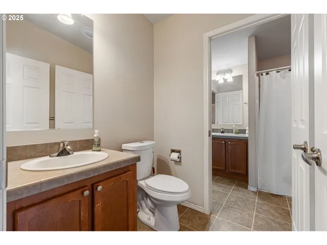 a bathroom with a sink a toilet a mirror and shower