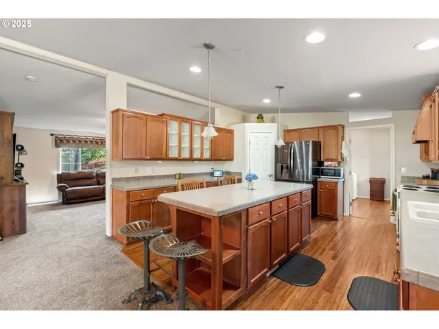 a kitchen with stainless steel appliances kitchen island granite countertop a sink and cabinets