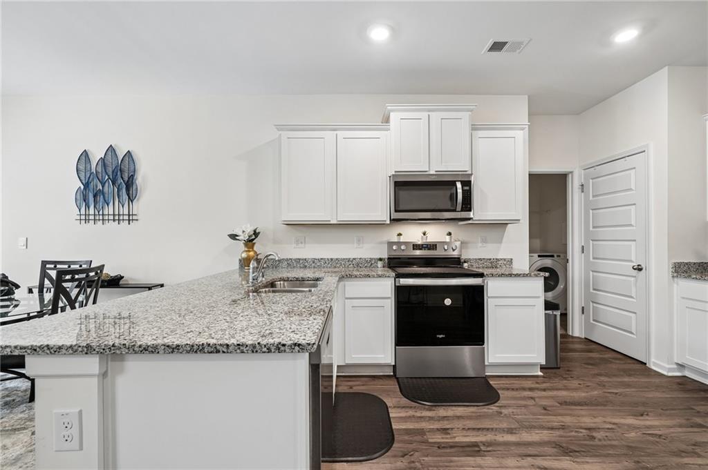 8592 Seabiscuit Road Lithonia, GA 30058 - Photo 6 of 25 a kitchen with granite countertop a stove top oven a sink and cabinets