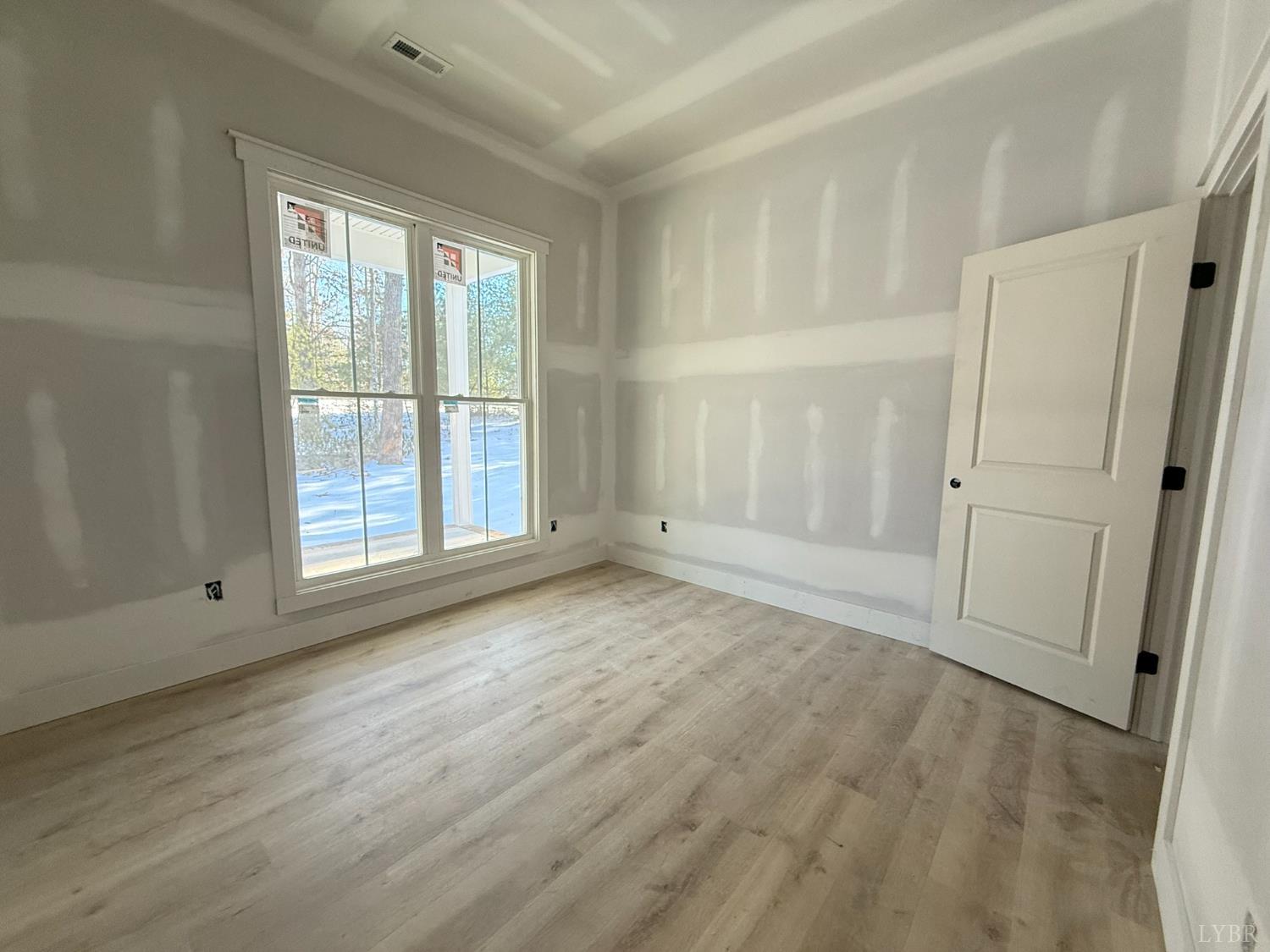 116 Blue Sky Court Monroe, VA 24574 - Photo 33 of 44 an empty room with wooden floor and a window