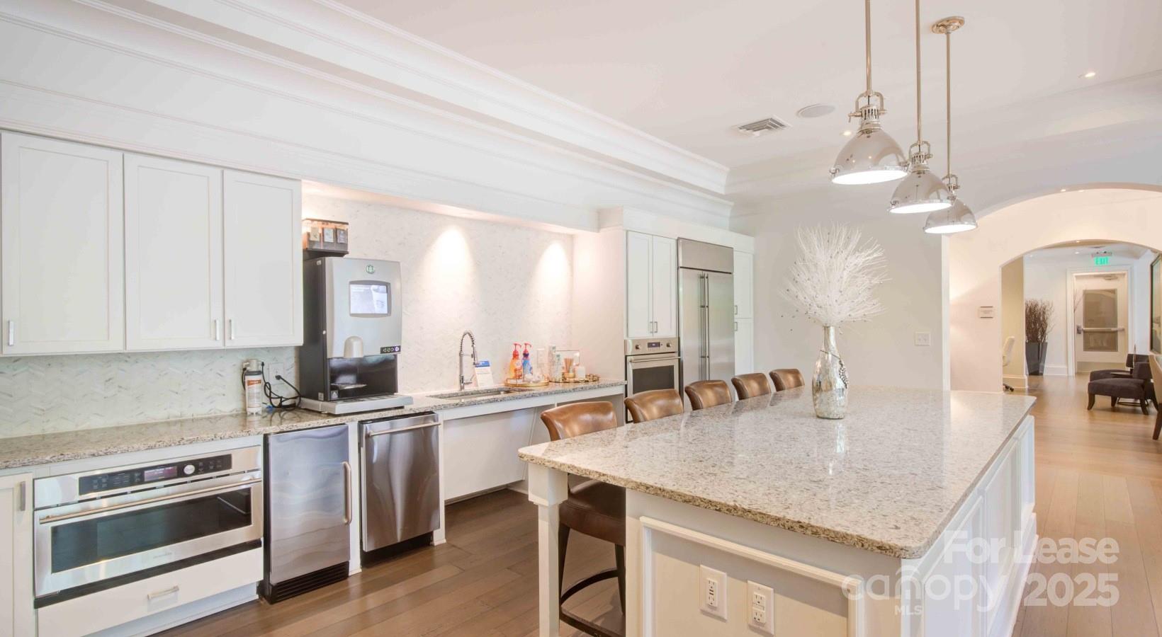 10624 Parrish Street, Unit B1 Matthews, NC 28105 - Photo 11 of 42 a kitchen with stainless steel appliances granite countertop a sink a stove and chairs