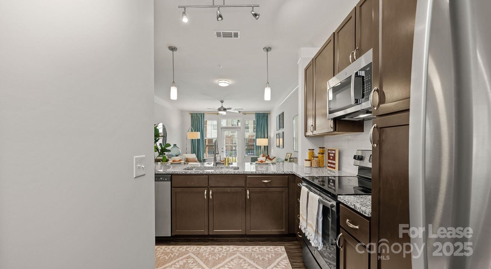 10624 Parrish Street, Unit B1 Matthews, NC 28105 - Photo 29 of 42 a kitchen with stainless steel appliances granite countertop a sink stove and cabinets