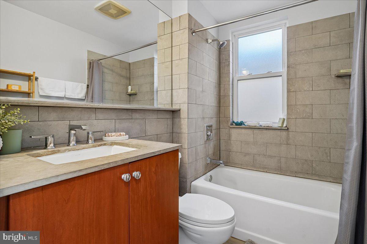 1121 24th Street Northwest, Unit 309 Washington, DC 20037 - Photo 18 of 20 a bathroom with a granite countertop sink toilet and shower