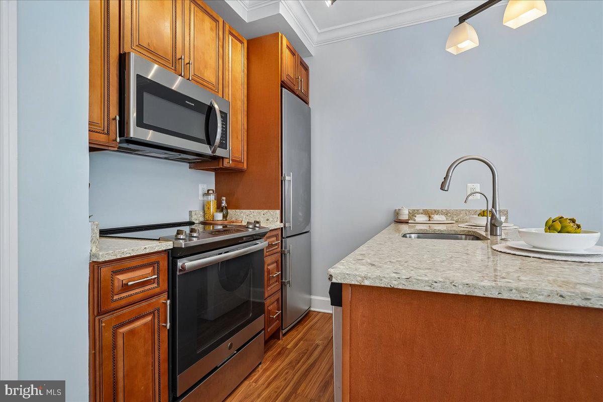 1121 24th Street Northwest, Unit 309 Washington, DC 20037 - Photo 7 of 20 a kitchen with stainless steel appliances granite countertop a stove a sink and a microwave