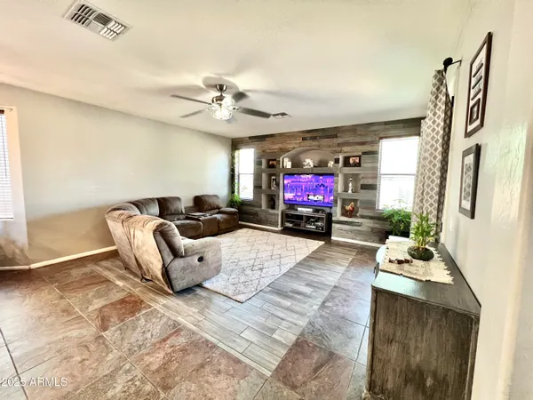 a living room with furniture a flat screen tv and a fireplace
