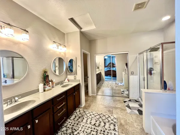 a large bathroom with a double vanity sink a mirror and a shower