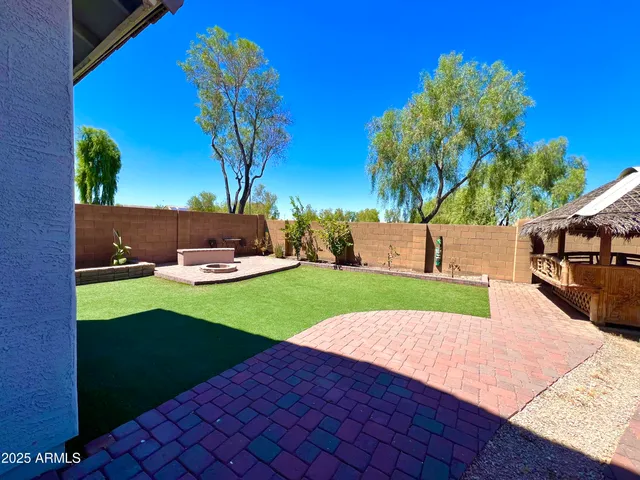 a view of a backyard with table and chairs with a barbeque grill and plants