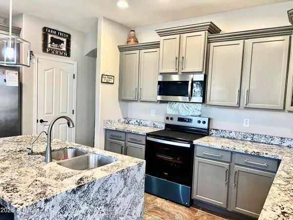 a kitchen with stainless steel appliances granite countertop a sink stove and refrigerator