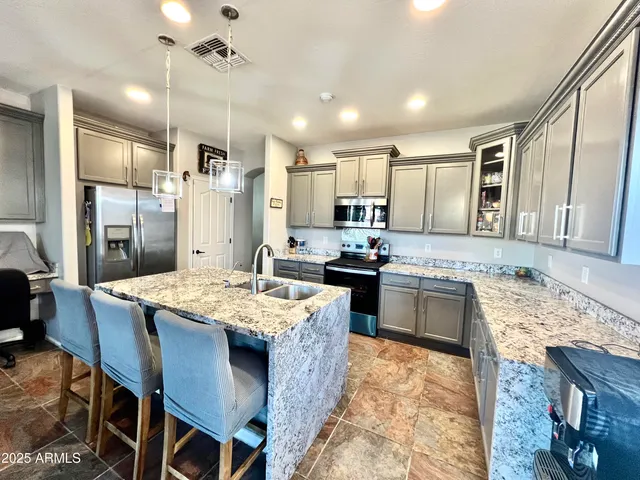 a open kitchen with granite countertop a sink stove and refrigerator